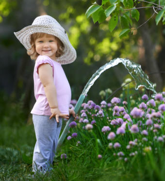 Little girl watering a garden